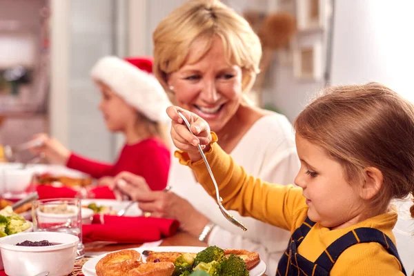 Mehrgenerationenfamilie Nikolausmützen Genießt Gemeinsam Weihnachtsessen Hause — Stockfoto