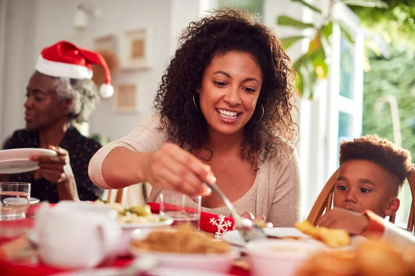 Multi Generation Family Paper Hats Enjoying Eating Christmas Meal Home — Stock Photo, Image