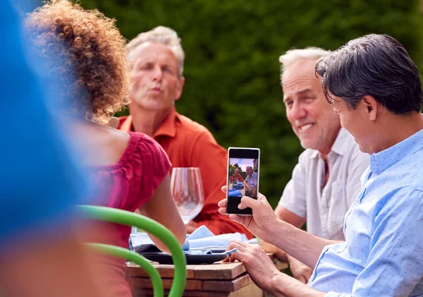 Hombre Tomando Fotos Como Grupo Amigos Hablando Alrededor Mesa Cena —  Fotos de Stock