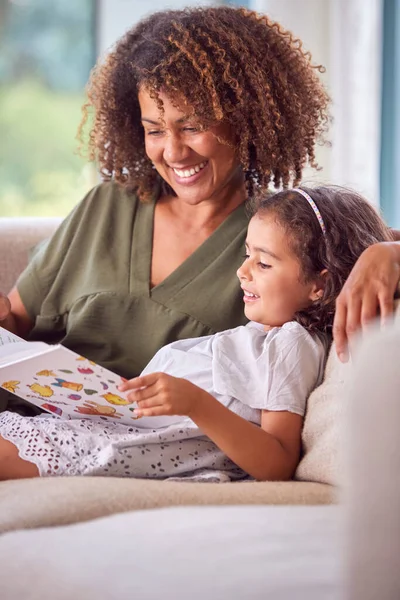 Mother Daughter Sitting Sofa Home Reading Book Together — Stock Photo, Image