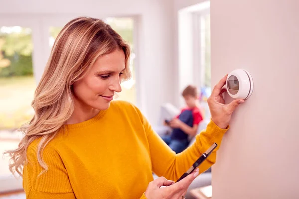 Madre Casa Con Hijo Ajustando Control Central Inteligente Del Termostato —  Fotos de Stock