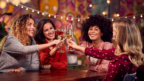 Multi-Cultural Group Of Female Friends Celebrating Making Toast Enjoying Party Night Out In Bar