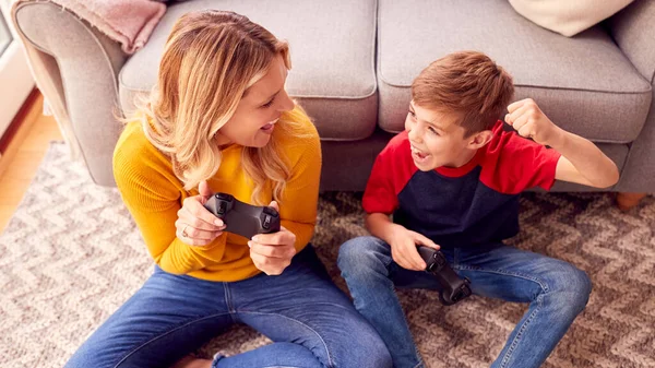 母亲和儿子在家里和男孩一起玩电子游戏庆祝他赢了 — 图库照片