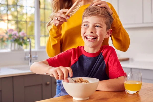 Zoon Thuis Eten Ontbijt Granen Keuken Teller Als Moeder Borstelt — Stockfoto