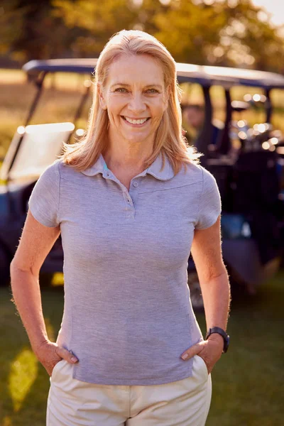 站在高尔夫球场跑车旁边笑的成熟女子高尔夫球手的画像 — 图库照片