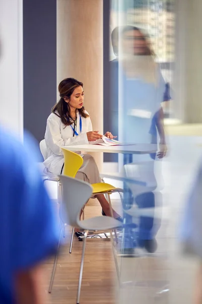 Γυναίκα Γιατρός Λευκό Παλτό Κάθεται Στο Τραπέζι Διαβάζοντας Σημειώσεις Ασθενών — Φωτογραφία Αρχείου
