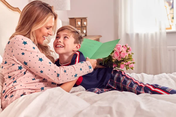 Liefdevolle Zoon Verrassende Moeder Bed Met Bloemen Zelfgemaakte Kaart Verjaardag — Stockfoto