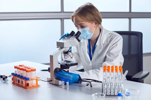 Vrouwelijke Laboratoriummedewerker Draagt Pbm Bloedmonsters Analyseren Het Laboratorium Met Microscoop — Stockfoto
