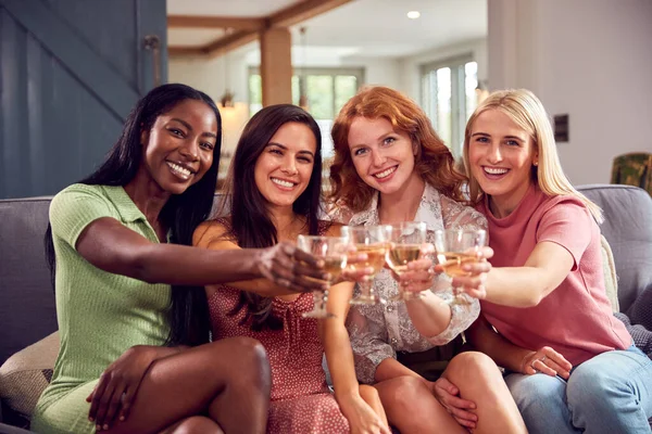 自宅でソファで女性の友人の多文化グループワインを飲み カメラに乾杯 — ストック写真