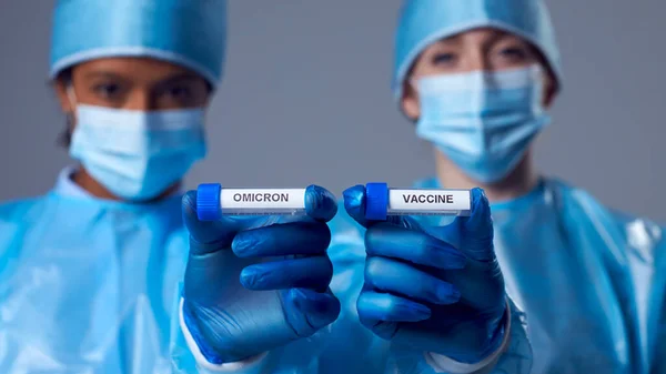 Dwie Pracownice Laboratoryjne Probówkach Testowych Opatrzonych Etykietą Omicron Vaccine — Zdjęcie stockowe