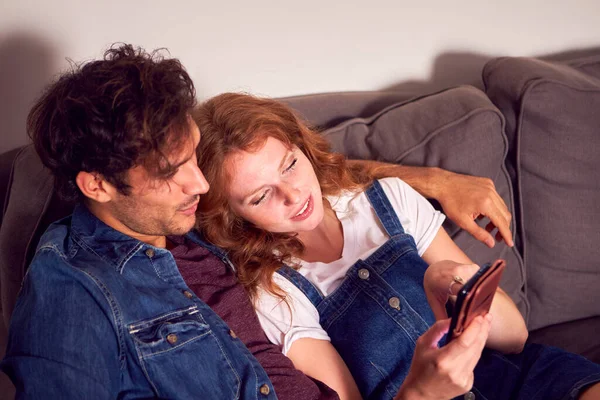 Couple Assis Sur Canapé Dans Salon Maison Regardant Leur Téléphone — Photo