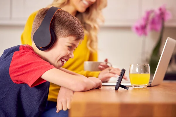 Jongen Keuken Kijken Film Mobiele Telefoon Dragen Van Draadloze Hoofdtelefoon — Stockfoto