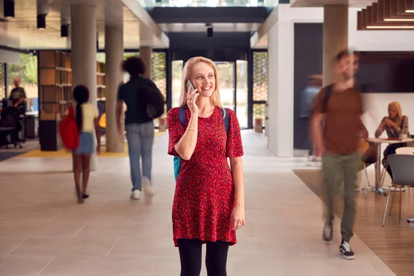 Vrouwelijke Student Praat Mobiele Telefoon Als Loopt Door Drukke Universiteit — Stockfoto