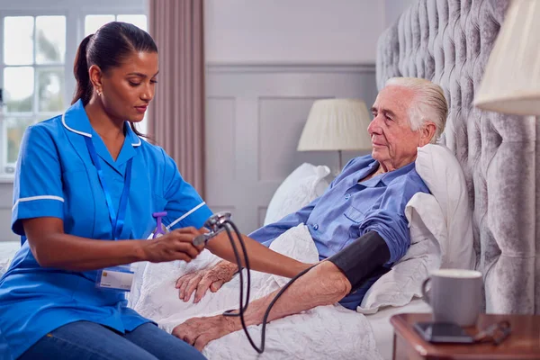 Senior Man Home Bed Having Blood Pressure Taken Female Care — Stockfoto