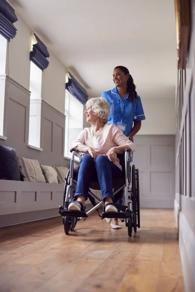 Senior Woman Home Being Pushed Wheelchair Female Care Worker Uniform — стоковое фото