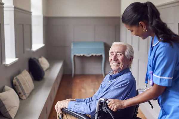 Senior Man Home Being Pushed Wheelchair Female Care Worker Uniform — Fotografia de Stock