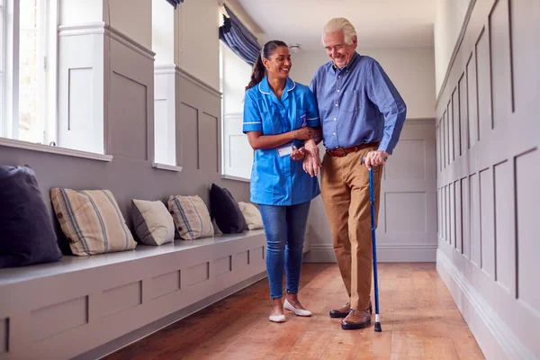 Senior Man Home Using Walking Stick Being Helped Female Care — Stock Photo, Image