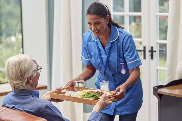 Female Care Worker Uniform Bringing Meal Tray Senior Man Sitting — Stock Photo, Image