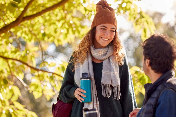 Sorridente Coppia Con Uomo Seduto Sulla Panchina Autunno Parco Salutarsi — Foto Stock