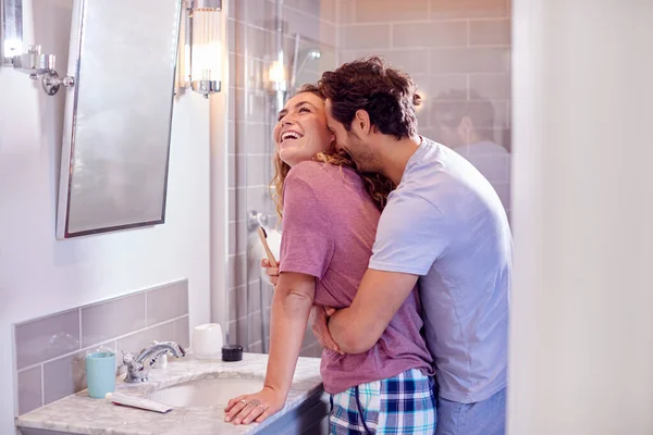 Man Hugging Woman Wearing Pyjamas Suite Bathroom She Brushes Her — Foto Stock