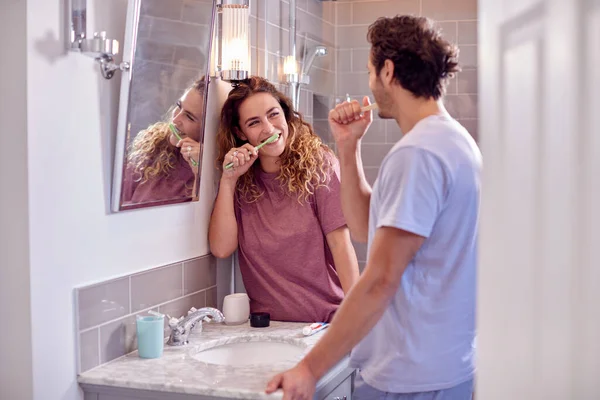 Couple Wearing Pyjamas Suite Bathroom Brushing Teeth Together — Fotografia de Stock