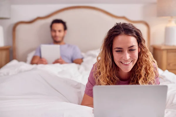 Couple Wearing Pyjamas Lying Bed Home Woman Using Laptop Man — Fotografia de Stock