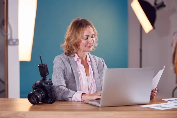 Mature Female Photographer Desk Laptop Checking Brief Fashion Shoot Studio — 스톡 사진