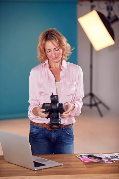 Mature Female Photographer Checking Camera Fashion Shoot Studio — Fotografia de Stock