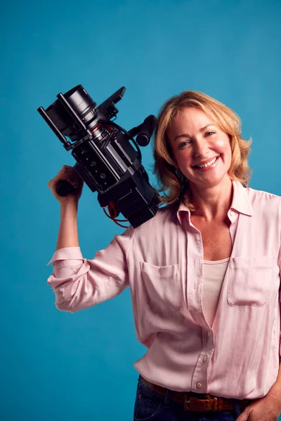 Mature Female Videographer Camera Filming Video Blue Background Shoot Studio — стоковое фото