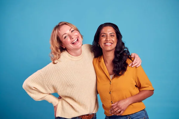 Porträtt Två Mogna Kvinnliga Vänner Skrattar Kameran Mot Blå Bakgrund — Stockfoto
