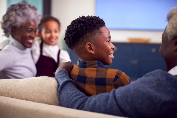 Rear View Grandparents Grandchildren Sitting Sofa Watching Movie Home — Zdjęcie stockowe