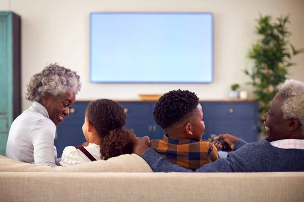 Rear View Grandparents Grandchildren Sitting Sofa Watching Movie Home — Stockfoto