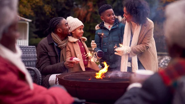 秋天花园中的多代家庭与烟火喷火器在一起玩乐 — 图库照片