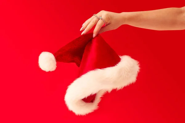 Close Studio Shot Woman Holding Christmas Santa Hat Red Background — Stockfoto