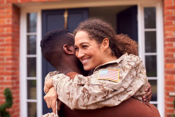 身着制服 离家回家的美国女兵在外面拥抱男人 — 图库照片