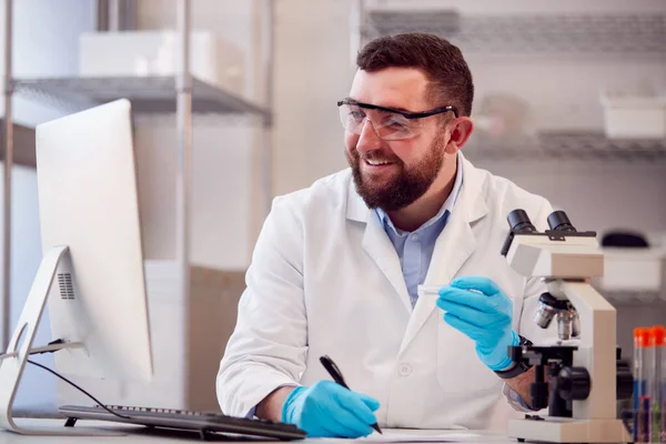 Male Lab Worker Wearing White Coat Recording Test Results Computer — Foto Stock