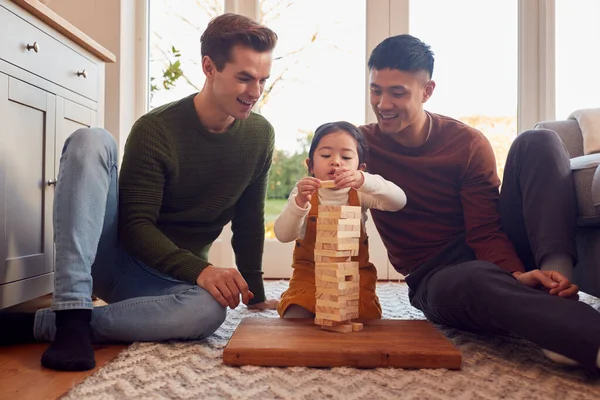 Family Two Dads Playing Game Daughter Home Stacking Wooden Bricks — стоковое фото