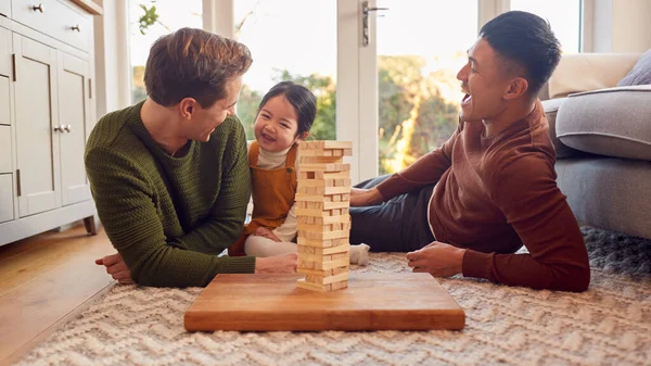 Family Two Dads Playing Game Daughter Home Stacking Wooden Bricks — стоковое фото