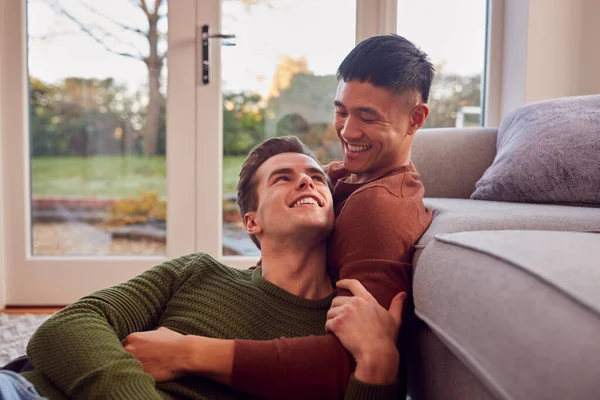 Loving Same Sex Male Couple Cuddling Sofa Home Together — стоковое фото
