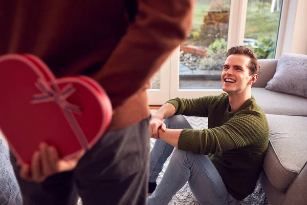 男人在家中惊喜同性伴侣背后带着心形礼物 — 图库照片