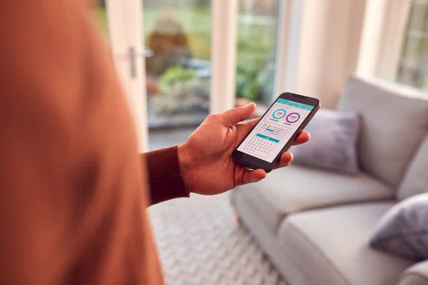 Primer Plano Del Hombre Casa Sosteniendo Teléfono Mirando Aplicación Fitness — Foto de Stock