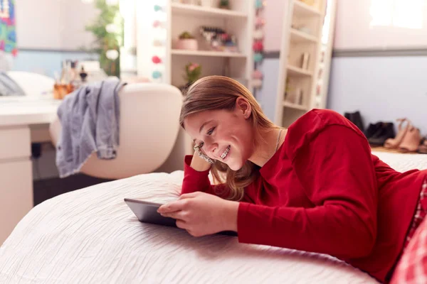 Teenage Girl Wearing Orthodontic Braces Lying Bed Home Using Digital — Stockfoto