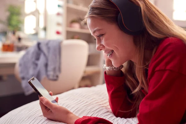 Teenage Girl Wearing Wireless Headphones Streaming Music Film Mobile Phone — стоковое фото