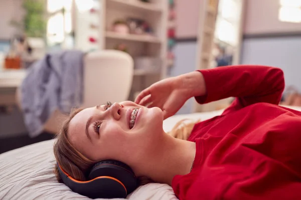 Teenage Girl Wearing Wireless Headphones Listening Music Lying Bed Bedroom — стоковое фото