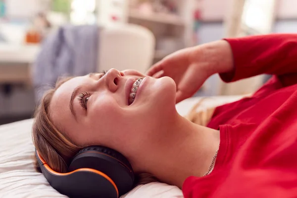 Teenage Girl Wearing Wireless Headphones Listening Music Lying Bed Bedroom — стоковое фото