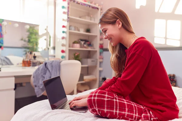 Teenage Girl Wearing Pyjamas Using Laptop Sitting Bed Bedroom — Fotografia de Stock