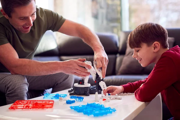Otec Syn Nosí Pyžamo Budování Robotické Paže Plastové Sady Doma — Stock fotografie