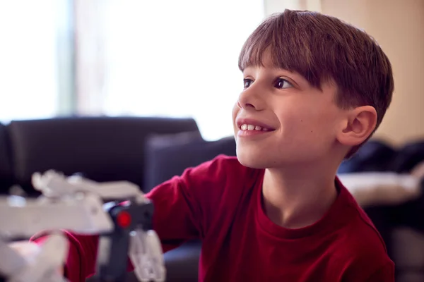 Junge Trägt Pyjama Und Baut Roboterarm Aus Plastikbausatz Hause — Stockfoto