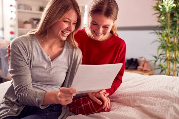 Smiling Teenage Daughter Wearing Pyjamas Looking School Exam Report Mother — Stok fotoğraf