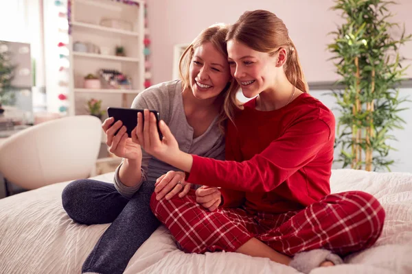 Mother Teenage Daughter Wearing Pyjamas Sitting Bed Posing Selfie Mobile — Stock fotografie